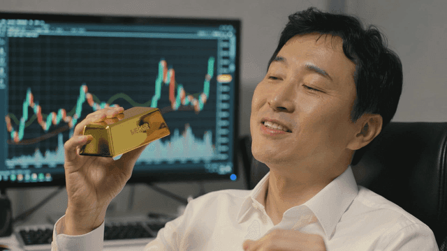 Smiling man holding gold bar in office