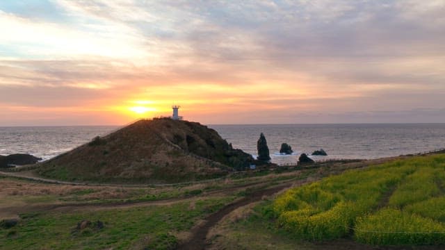 Sunset over a coastal lighthouse and sea