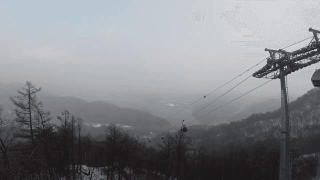 Cable cars moving over a snowy mountain