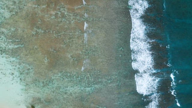 Aerial View of Crashing Waves on Shore