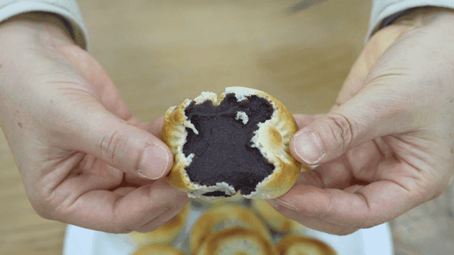 A person holding a red bean-filled pastry