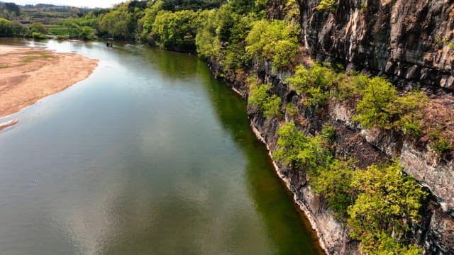 Tranquil river flowing beside rocky cliffs