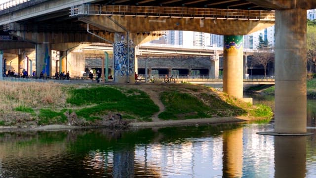 Under the bridge with people and bicycles