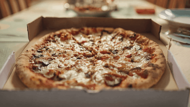 테이블 위 상자에 담긴 갓 구운 피자