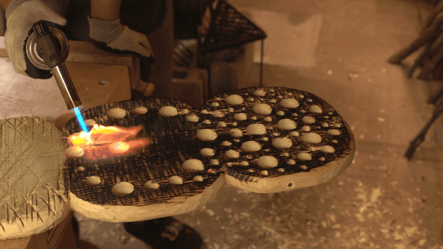 작업장에서 토치로 나무 태우기