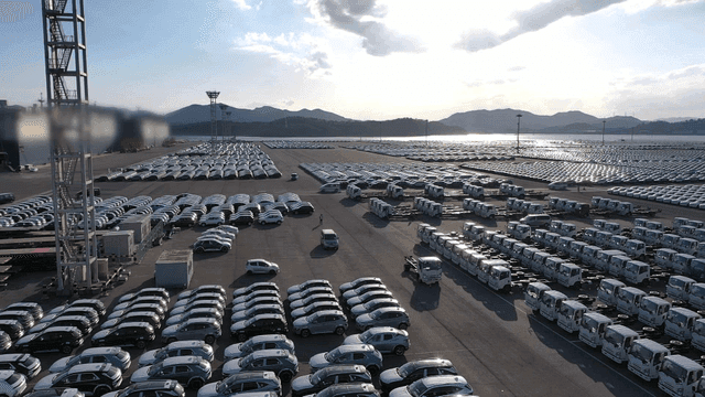 Large parking lot filled with cars and trucks