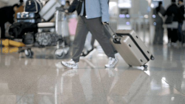 공항에서 짐을 끌고 걷는 사람들