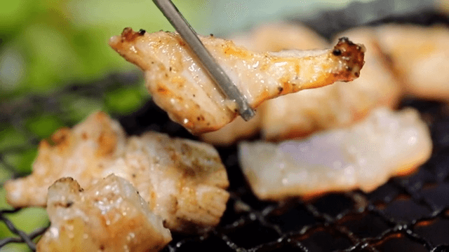 Grilled beef tripe picked up with chopsticks