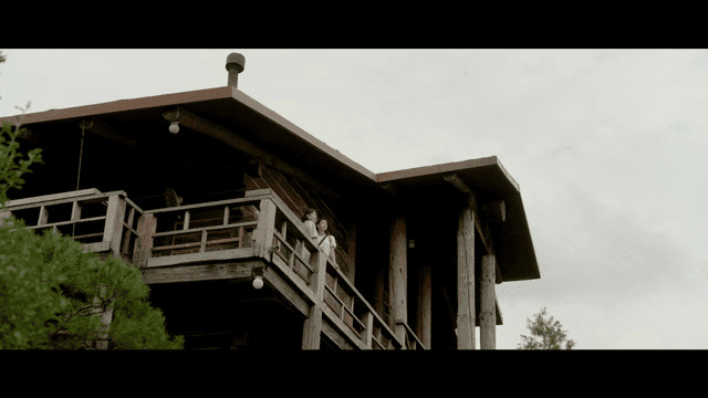 Two women on a wooden balcony of a cabin