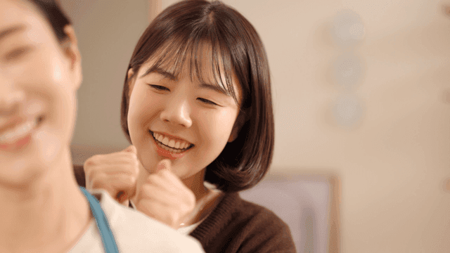 Daughter patting and massaging her mother's shoulder