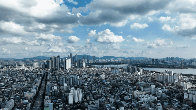 Panoramic view of city spread out under cloudy sky