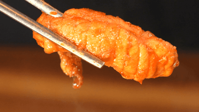 Spicy pufferfish bulgogi held with chopsticks