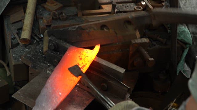 Forging a glowing hot metal piece