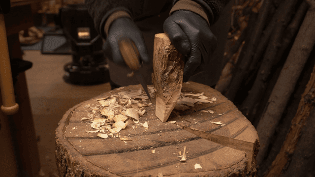 아늑한 작업실에서 도끼로 나무를 조각하는 목공예가