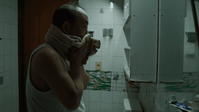 Man washing his face in bathroom