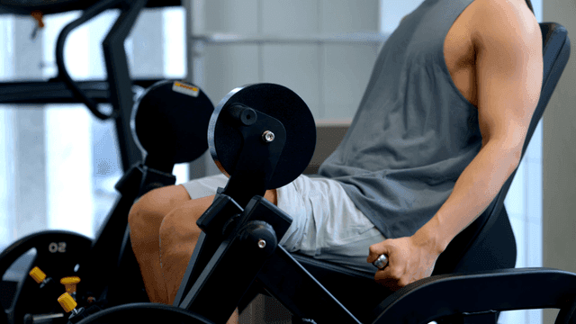 레그 익스텐션 머신에서 운동하는 남자