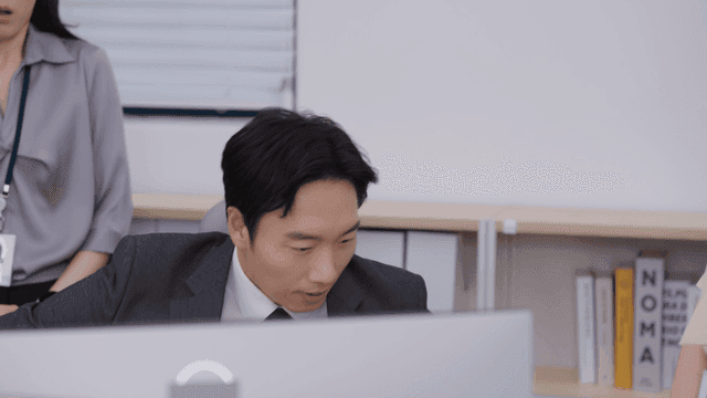 책상 주위에 모여 꾸중을 듣는 사무실 직원들