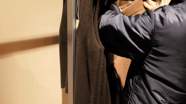 Person choosing clothes hanging on hanger