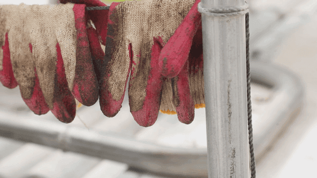 금속 기둥에 걸린 더러운 작업 장갑