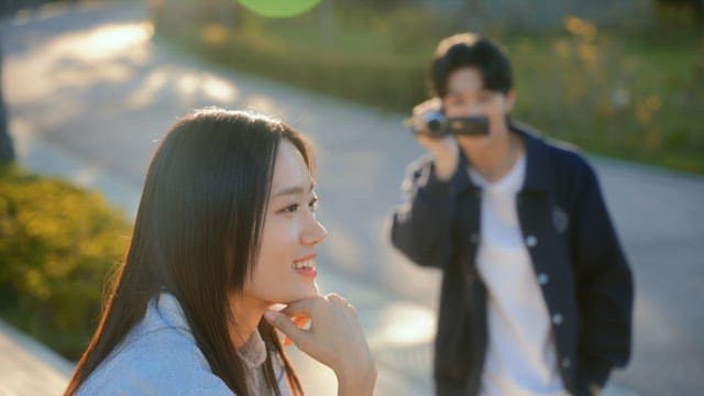 공원에서 캠코더로 영상을 찍는 커플