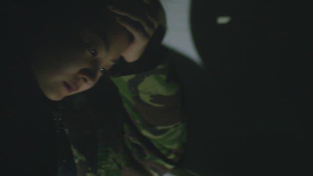 어두운 방에서 심각한 표정으로 머리를 쓸어넘기는 여자