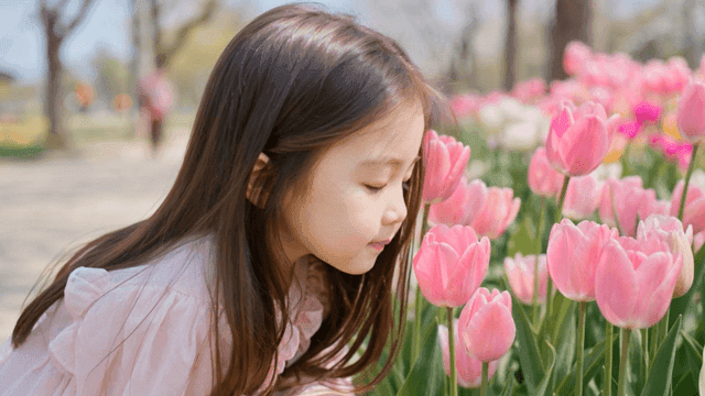 Girl enjoying tulips in garden