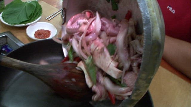 팬에 쏟아지는 손질된 꼼장어와 채소