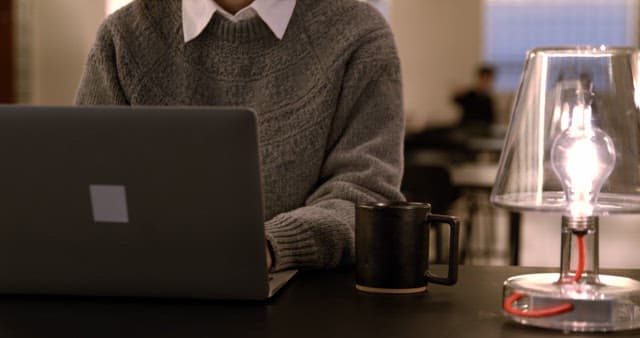 Adult Working on Laptop with a Cup of Warm Coffee