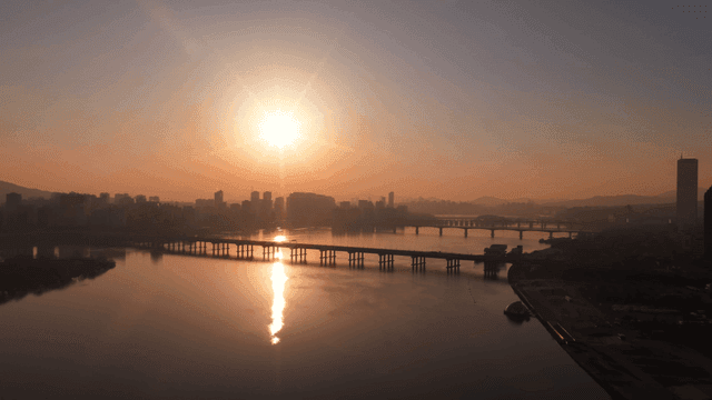 Sunrise over a city skyline and river