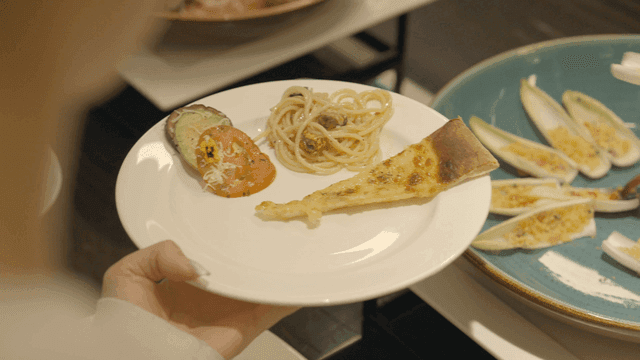 A plate with pizza, pasta, and salad