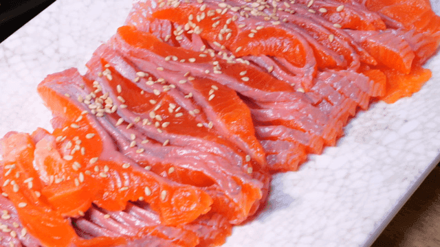 Vivid orange trout sashimi on plate