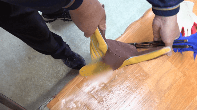 가죽 글러브의 모양을 잡는 작업자