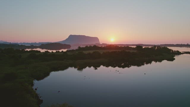 Sunset over a serene landscape with distant mountain