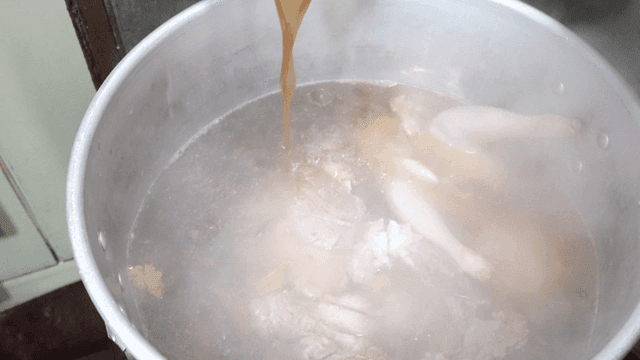 Soy sauce broth boiling in pot with meat