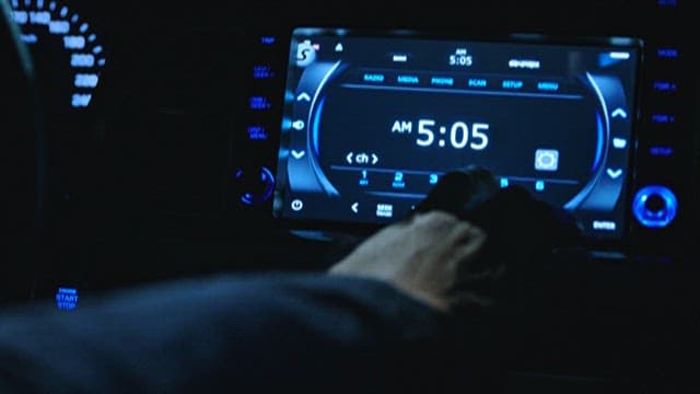 Hand Changing Radio Stations in a Car at Night