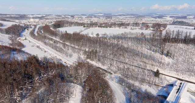 Snowy Landscape with Train Passing Through