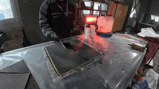 Worker applying resin on carbon fiber sheet