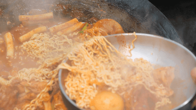 Ramen, potatoes, and cast-iron pot lid spicy chicken stew spreading across bowl