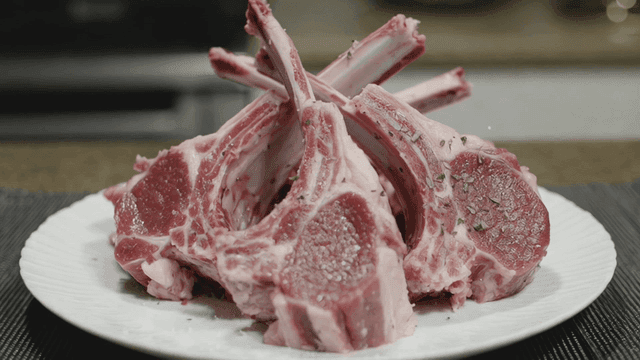 Raw lamb chops seasoned on a plate
