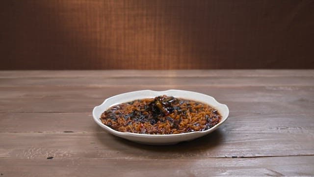 Steaming plate of Jajang Ramen on a wooden table