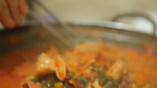 Chopstickful of boiling intestine stew made with sundae, mushrooms, and vegetables