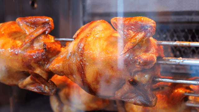꼬치에 끼워져 기름이 떨어지는 전기구이 통닭