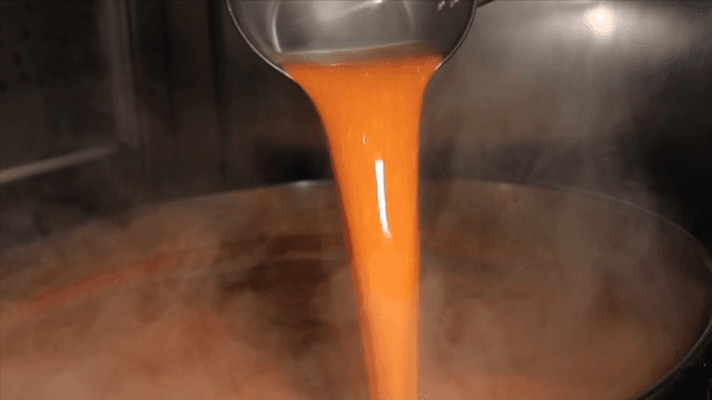 국자로 붉은 국물을 냄비에 붓는 장면