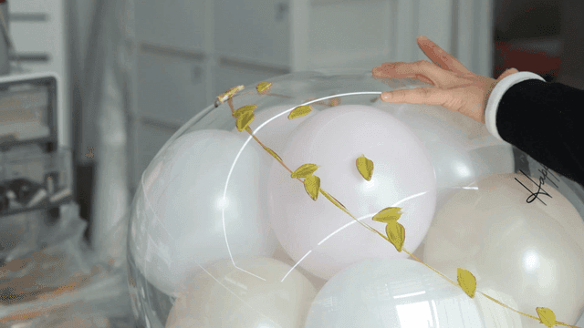 Hand applying paint to balloon with spatula