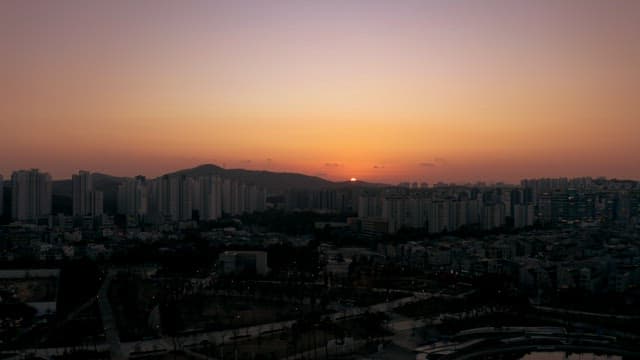 Sunset Skyline with Cityscape and Mountains