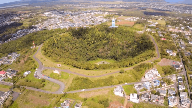 도시 속 숲이 우거진 분화구의 항공 뷰