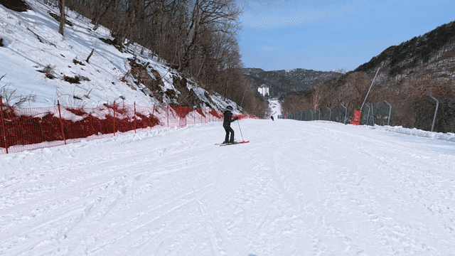 Skier going down snow-covered slope