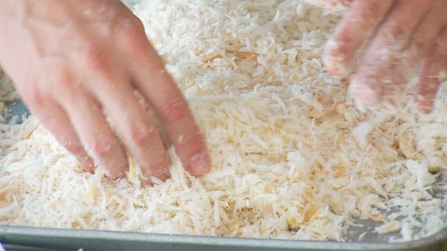 생선 튀김을 만들기 위해 계란물을 입힌 생선에 튀김옷 입히기