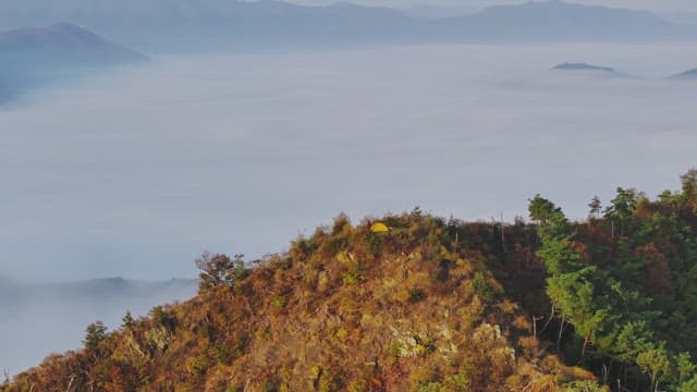 구름 낀 산 꼭대기에서 캠핑하는 모습