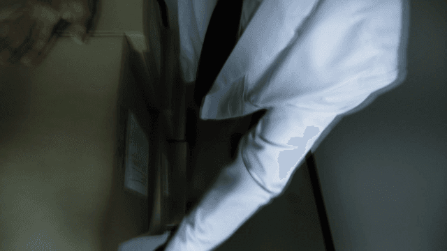 Office workers hastily moving documents in narrow office hallway